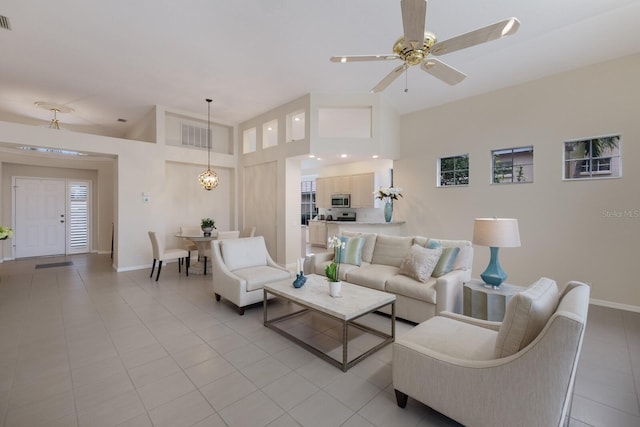 tiled living room with high vaulted ceiling and ceiling fan