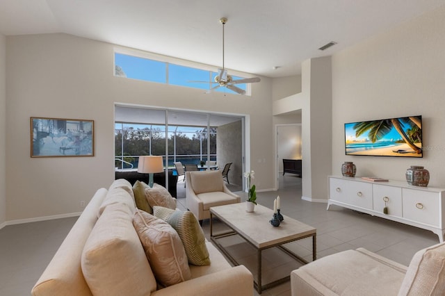 living room featuring ceiling fan, light tile patterned floors, and vaulted ceiling