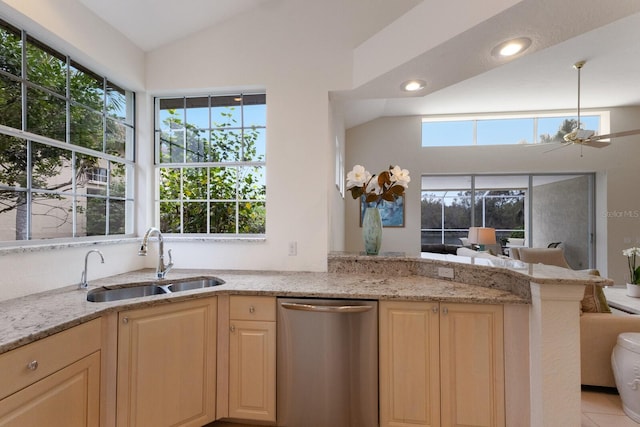 kitchen featuring light stone counters, sink, stainless steel dishwasher, and vaulted ceiling