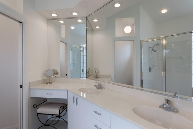 bathroom with vanity and a shower with door