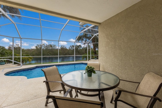 view of swimming pool featuring a lanai, a water view, and a patio