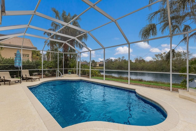 view of pool with a patio area, glass enclosure, and a water view