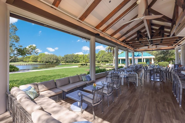 view of patio with ceiling fan, an outdoor living space, and a water view