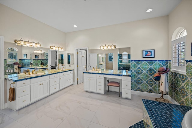 bathroom featuring vanity and tile walls