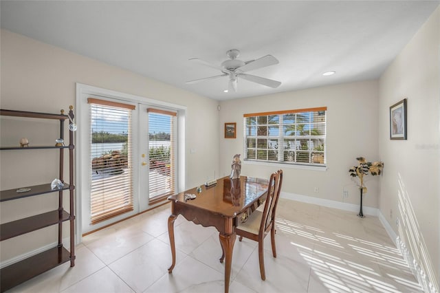 tiled dining space featuring ceiling fan and french doors