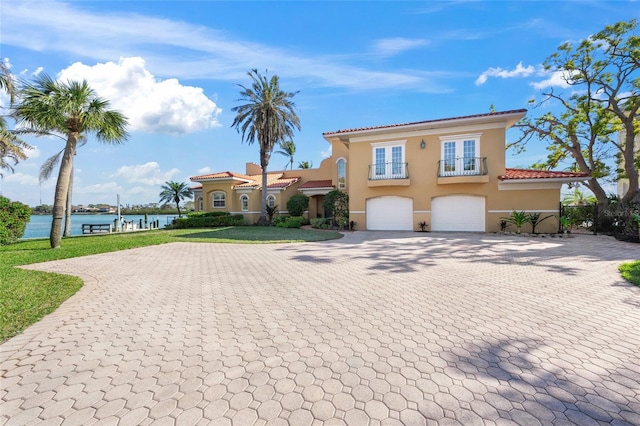 mediterranean / spanish house featuring a garage and a water view