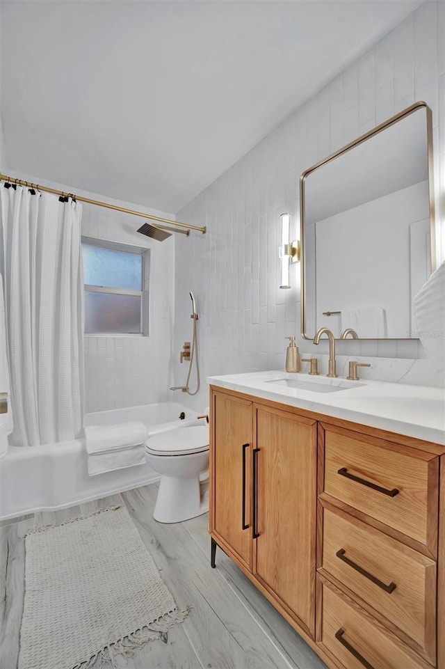 full bathroom featuring toilet, vanity, tile walls, hardwood / wood-style flooring, and shower / tub combo with curtain