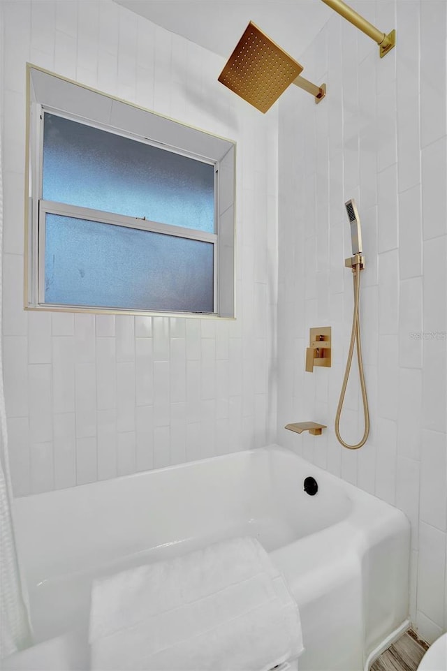 bathroom featuring tiled shower / bath