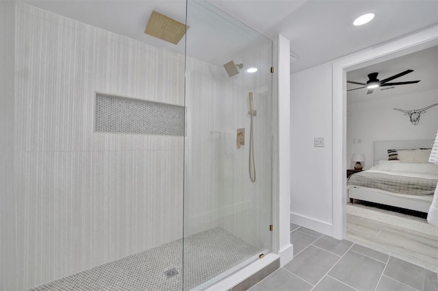 bathroom with tiled shower, tile patterned flooring, and ceiling fan