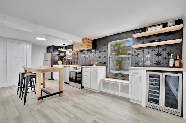 kitchen with white cabinets, dishwasher, refrigerator, beverage cooler, and stainless steel range with electric stovetop