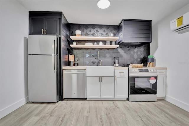 kitchen with stainless steel appliances, sink, white cabinets, wall chimney exhaust hood, and decorative backsplash