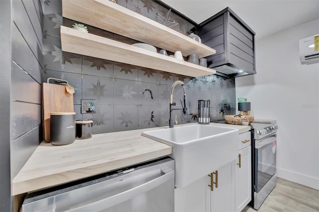 kitchen featuring stainless steel appliances, light hardwood / wood-style floors, decorative backsplash, white cabinets, and sink