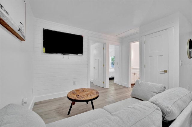 living room with ornamental molding and light hardwood / wood-style floors