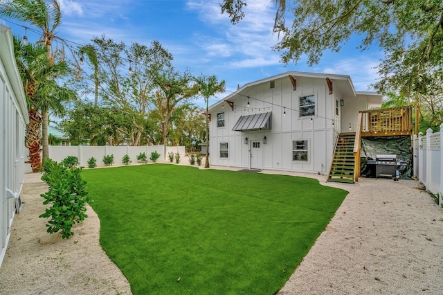 rear view of house featuring a yard and a wooden deck