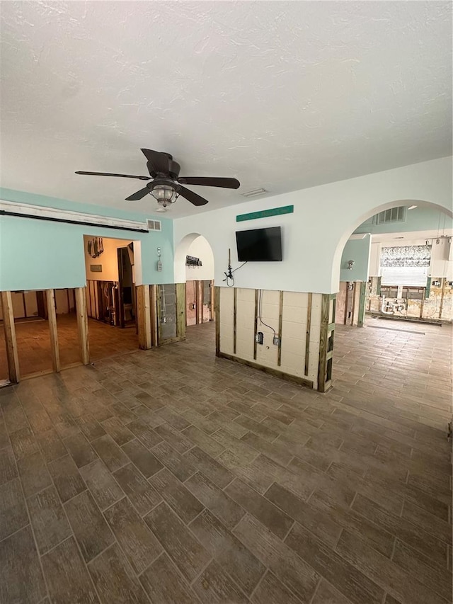 empty room with a textured ceiling and ceiling fan