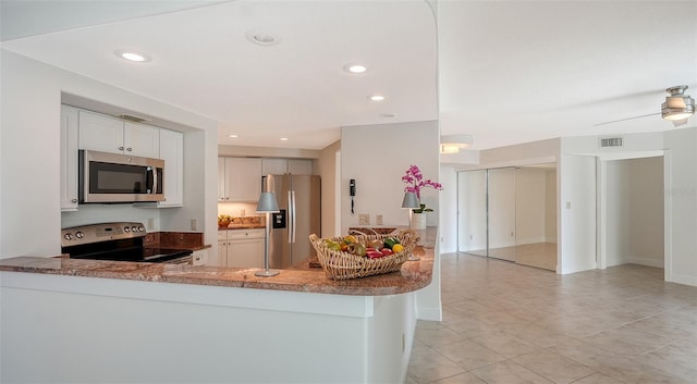 kitchen featuring white cabinetry, kitchen peninsula, ceiling fan, appliances with stainless steel finishes, and light tile patterned flooring