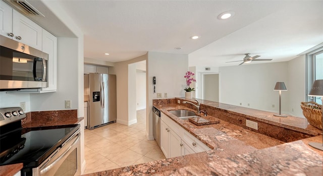 kitchen featuring sink, white cabinets, stainless steel appliances, and dark stone counters