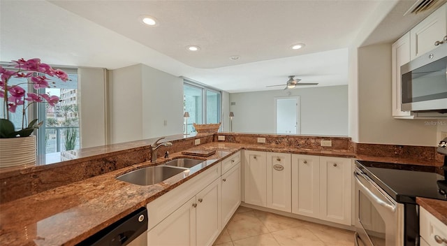 kitchen with white cabinets, stainless steel appliances, dark stone countertops, sink, and ceiling fan