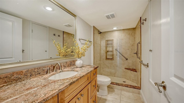 bathroom featuring toilet, tile patterned flooring, tiled shower, and vanity