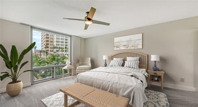 carpeted bedroom featuring ceiling fan and a wall of windows