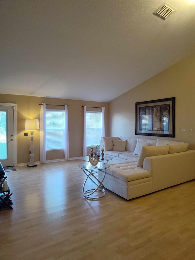 living room featuring vaulted ceiling and light hardwood / wood-style floors