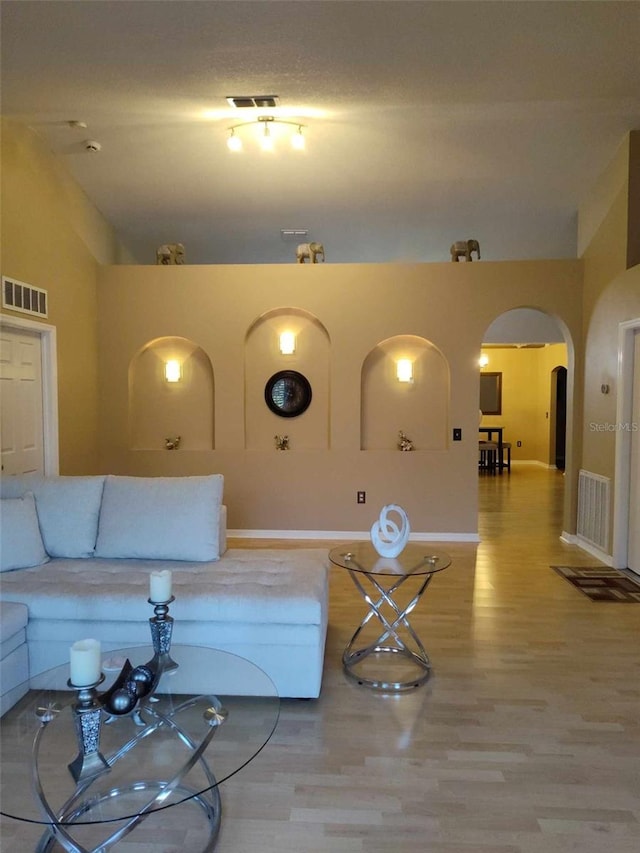 living room featuring lofted ceiling and hardwood / wood-style floors