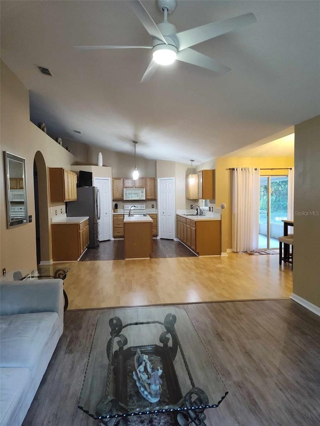 unfurnished dining area featuring lofted ceiling, sink, ceiling fan, and dark hardwood / wood-style floors