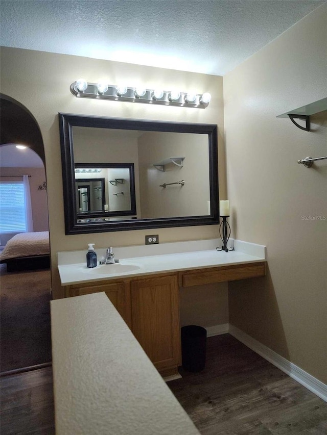 bathroom with hardwood / wood-style flooring, a textured ceiling, and vanity