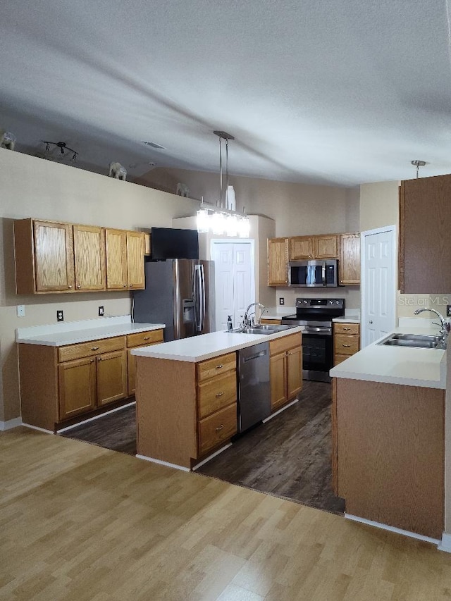 15900 SW 19th Avenue Rd, Ocala, FL 34473 - kitchen with stainless steel appliances, dark wood finished floors, a kitchen island with sink, light countertops, and hanging light fixtures