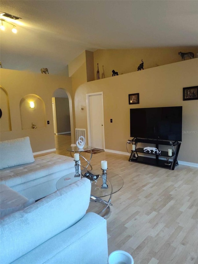 15900 SW 19th Avenue Rd, Ocala, FL 34473 - living room featuring arched walkways, lofted ceiling, and wood finished floors