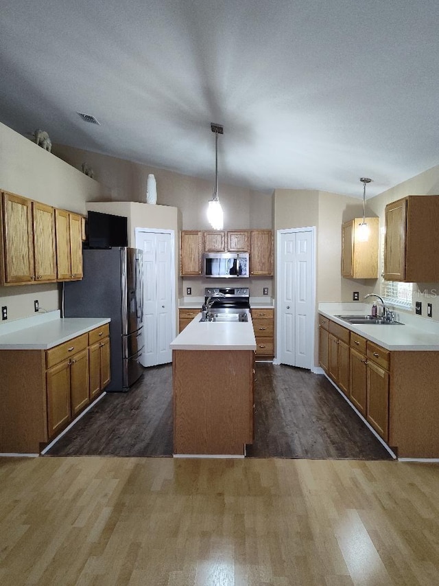 15900 SW 19th Avenue Rd, Ocala, FL 34473 - kitchen with stainless steel appliances, dark wood-style flooring, a center island with sink, decorative light fixtures, and light countertops