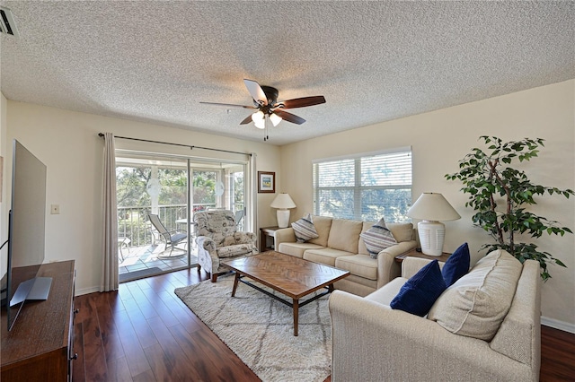 living room with ceiling fan, dark hardwood / wood-style floors, and a textured ceiling