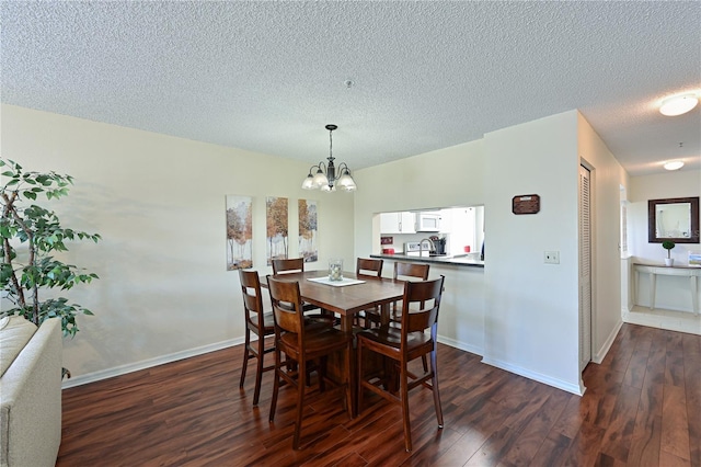 dining space featuring an inviting chandelier, a textured ceiling, and dark hardwood / wood-style flooring