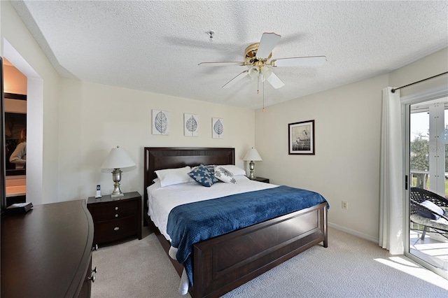 carpeted bedroom with access to outside, a textured ceiling, and ceiling fan