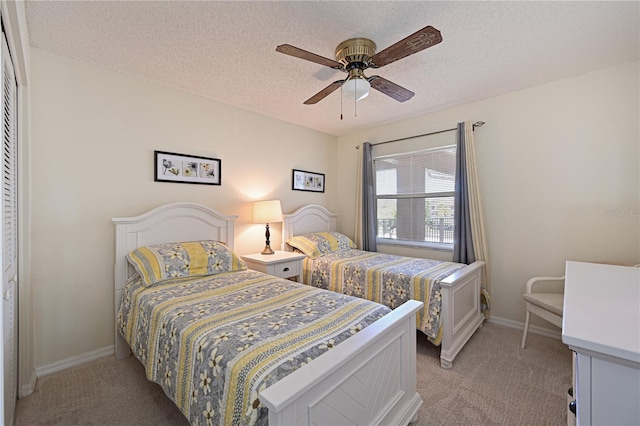 carpeted bedroom with a textured ceiling, ceiling fan, and a closet