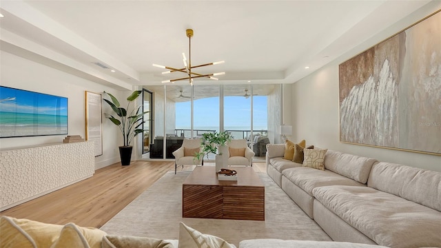 living room with floor to ceiling windows, light hardwood / wood-style floors, and an inviting chandelier