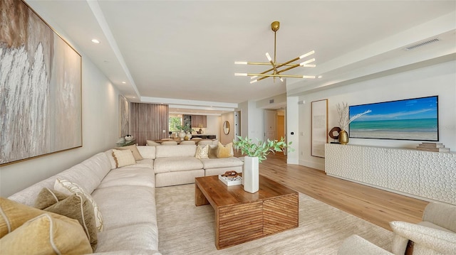 living room featuring an inviting chandelier and light hardwood / wood-style floors