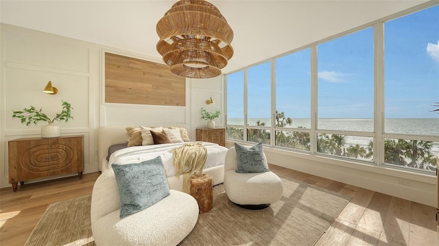 sunroom featuring a water view and a beach view