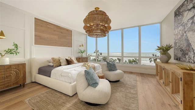 bedroom featuring a water view and light hardwood / wood-style flooring