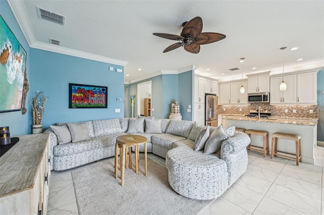 living room with ceiling fan and ornamental molding