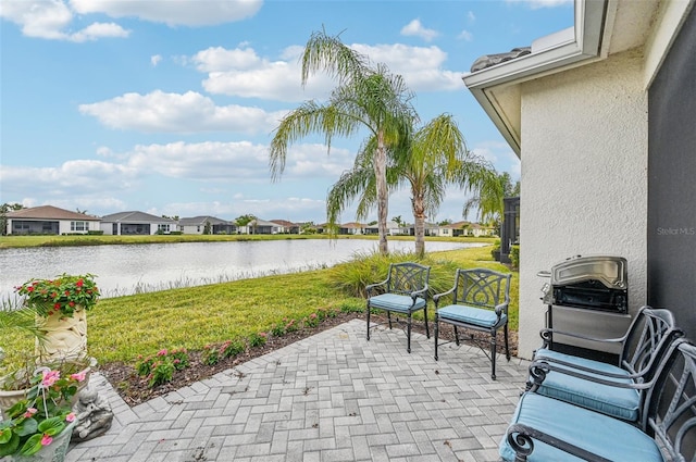 view of patio featuring a grill and a water view