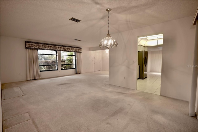 carpeted spare room with a textured ceiling