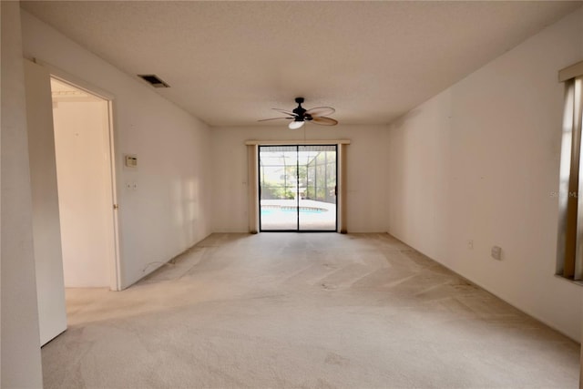 spare room with ceiling fan and light colored carpet