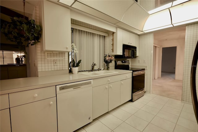 kitchen featuring white dishwasher, light colored carpet, stainless steel electric range, white cabinets, and sink