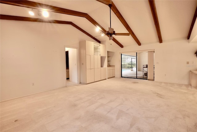 unfurnished living room featuring ceiling fan, beamed ceiling, light colored carpet, and high vaulted ceiling