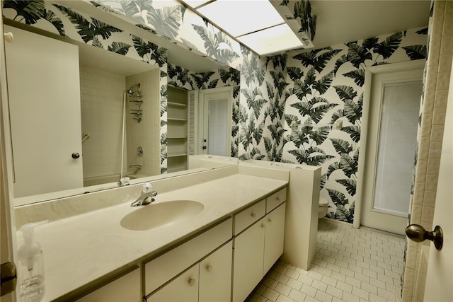 bathroom with tile patterned floors, vanity, and tiled shower / bath