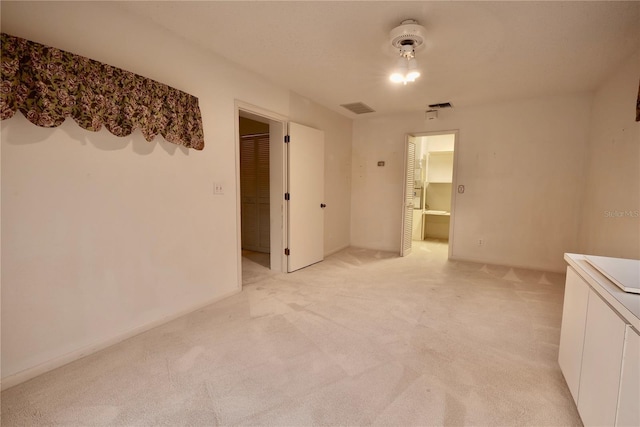 unfurnished bedroom with light carpet, a closet, and a spacious closet