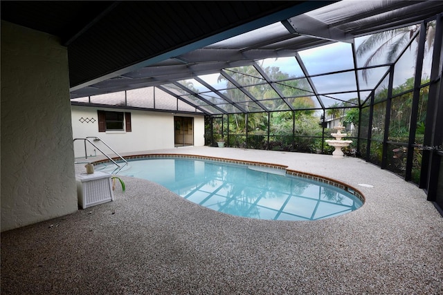 view of pool featuring glass enclosure and a patio