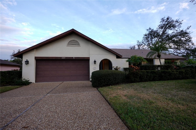 ranch-style house featuring a garage and a front yard