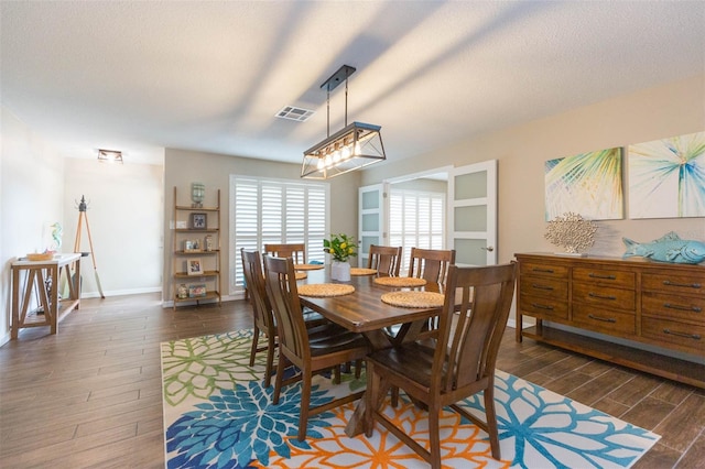 dining space with dark hardwood / wood-style floors and a textured ceiling